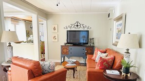 A living room with two leather sofas, a television, and a small table with a plant.