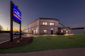 A modern building with a sign for Howard Johnson by Wyndham, a parking lot, and well-maintained lawn. - Howard Johnson by Wyndham Thunder Bay (Thunder Bay)