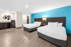A hotel room with two beds, a kitchenette, and a blue accent wall. - Howard Johnson by Wyndham Thunder Bay (Thunder Bay)