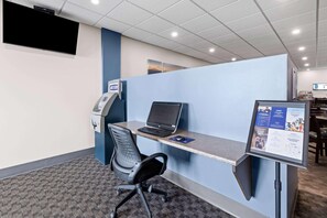 A modern office cubicle with a desk, chair, computer, and a digital kiosk. - Howard Johnson by Wyndham Thunder Bay (Thunder Bay)