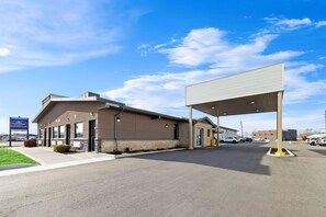 A commercial building with a gas station, a covered parking area, and a clear sky. - Howard Johnson by Wyndham Thunder Bay (Thunder Bay)