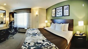 A hotel room with a bed, a desk, a chair, a desk lamp, and a nightstand with a phone. - Wingate by Wyndham Bel Air I-95 Exit 77A / APG Area (Edgewood)