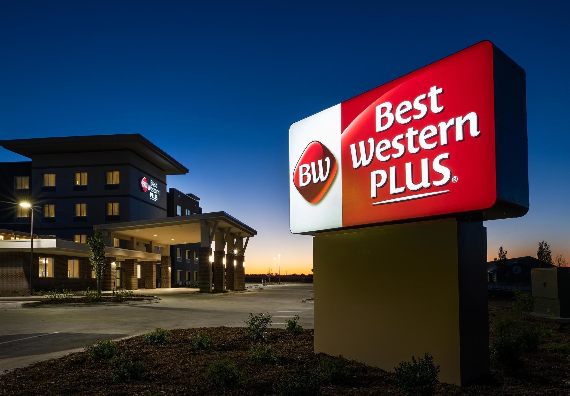 A Best Western Plus sign in front of a hotel building at dusk.