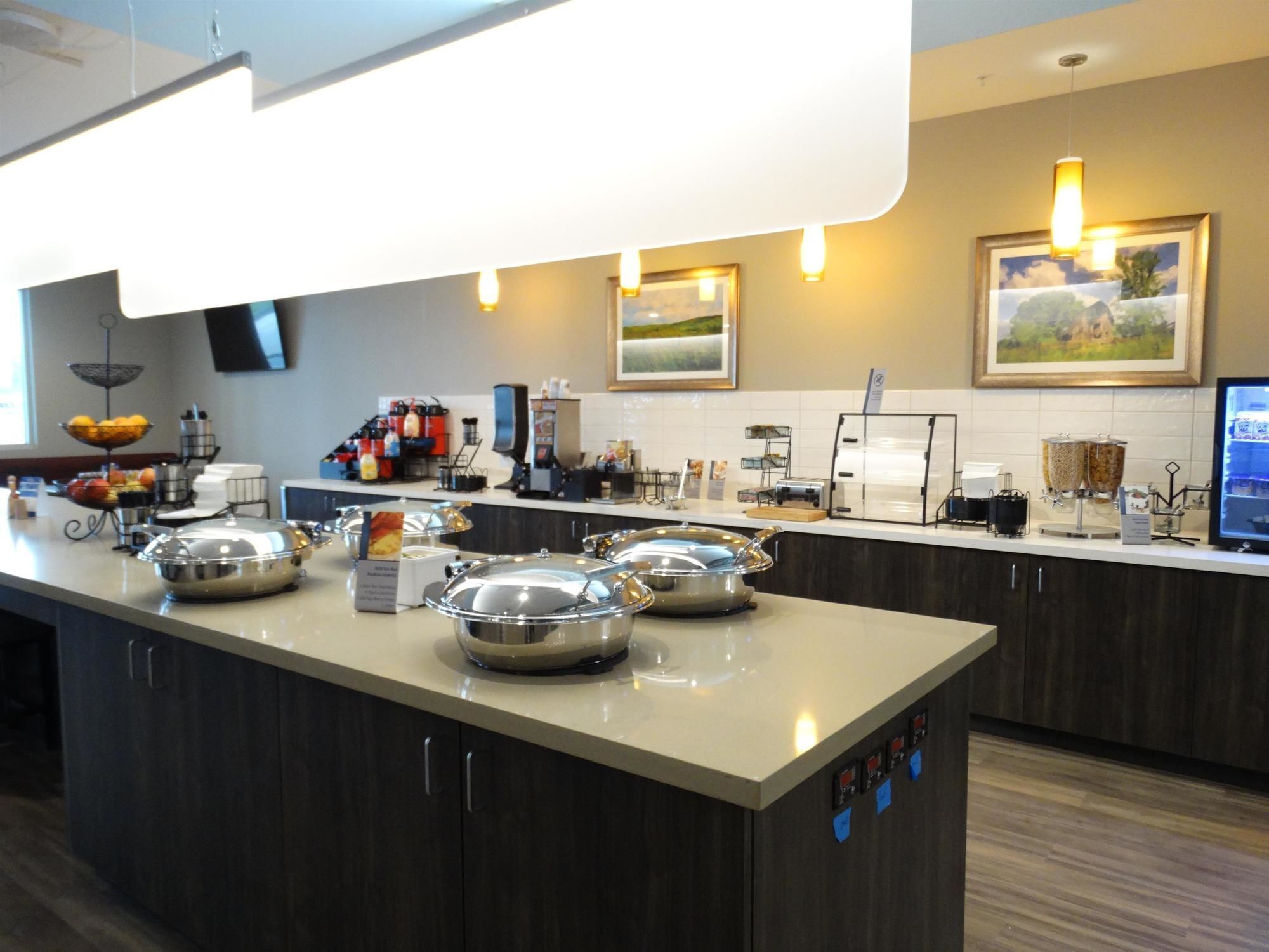 Een moderne keuken met een centraal eiland, voorzien van horeca-apparatuur en een koffiehoek.