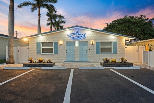 A motel with a shark sign, two doors, and a parking lot. - Shark Tank Cocoa Beach • 2 Units • Perfect for Families•Walk to Beach, Bars, & Shops (Cocoa Beach)