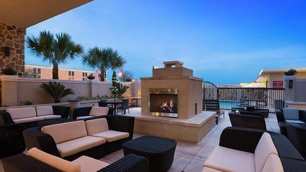 A rooftop lounge with outdoor seating, a fire pit, and a pool in the background. - Doubletree By Hilton San Antonio Northwest (San Antonio)
