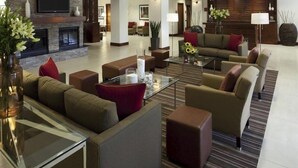 Un hall d’hôtel moderne doté d’une cheminée, de sièges confortables et d’un téléviseur à écran plat.