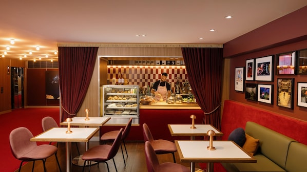 Un restaurante con mostrador, zona de mesas y vitrina.