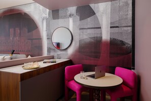 A modern room with a round mirror, a laptop on a small table, and two pink chairs. - Hotel Indigo Sydney Potts Point (Sydney)