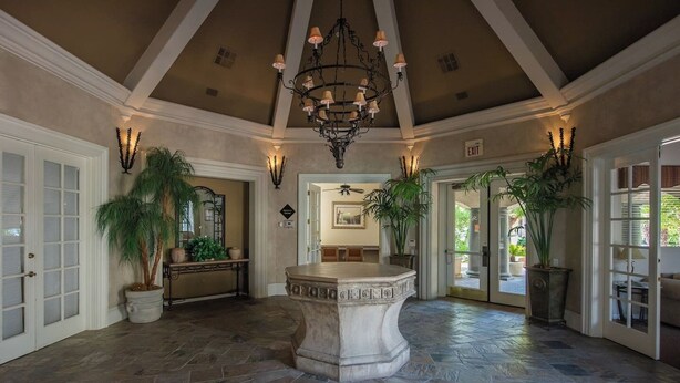 A spacious foyer with a stone floor, a central marble feature, and multiple potted plants. - Luxury Comfort close to Westworld & TPC + Pool&Spa (Scottsdale)