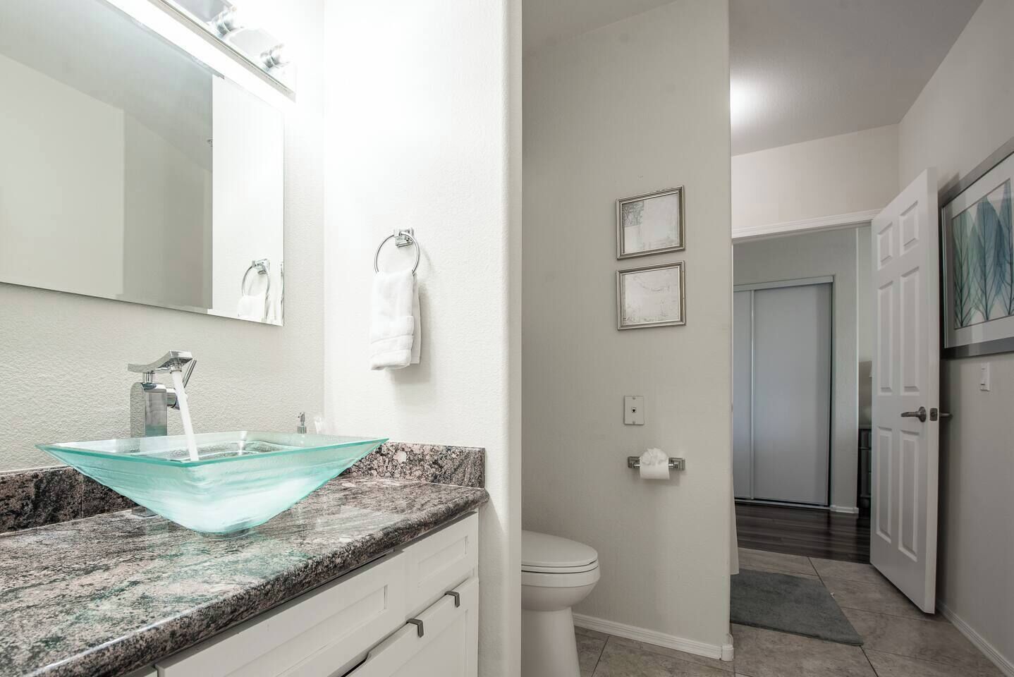 Een badkamer met een wastafel op voet, een toilet en een douchehoek.