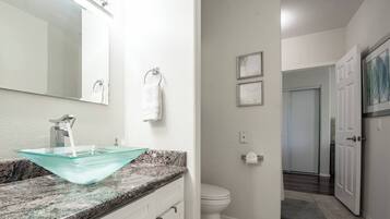 Een badkamer met een wastafel op voet, een toilet en een douchehoek.
