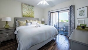A bedroom with a bed, bedside tables, a ceiling fan, a sliding glass door to a balcony, and artwork on the walls. - Luxury Comfort close to Westworld & TPC + Pool&Spa (Scottsdale)