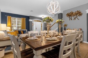 Enjoy meals in this inviting dining area with a beautifully set table, elegant centerpiece, and comfortable seating.