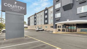 A Country Inn & Suites by Radisson building with a parking lot in front. - Country Inn & Suites by Radisson, Rehoboth Beach - Dewey (Rehoboth Beach)