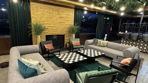 Un área de estar moderna con sofás, sillones y una mesa de centro con estampado de cuadros.