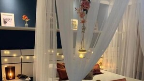 A bedroom with a canopy bed, bedside table with a lamp, and a nightstand. - Hotel Marlen (Cabo Frio)