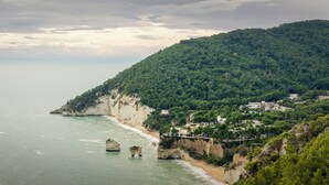 Un paisaje costero con un acantilado, playa y edificios.
