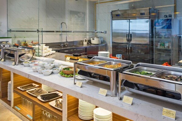 Un buffet avec différents postes de service, comprenant un réfrigérateur et un évier.