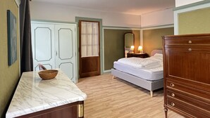 Un dormitorio con cama, mesita de noche, cómoda y espejo.