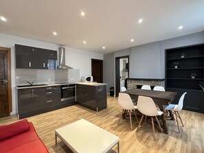 A modern kitchen with dark cabinets, a microwave, and a built-in oven.