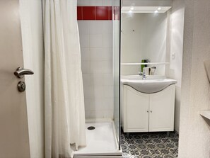 A bathroom with a shower, a sink, and a mirror.