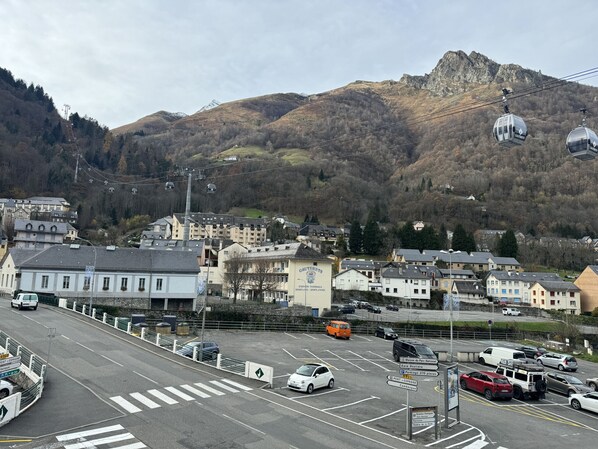 A parking lot with cars, a building with a sign, and a mountain in the background.