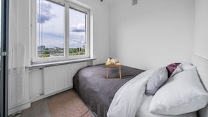 A bedroom with a bed, a window, and a radiator. - Śródmieście Apartment - 8th Floor, Workspace, Tram - by Rentujemy (Warszawa)