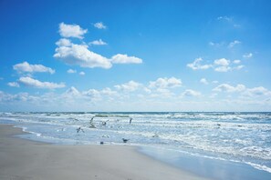 A beach with waves, sand, and a clear sky. - Beach View Newly remodel 1 bedroom condo in N Padre Island, Corpus Christi TX (Corpus Christi)