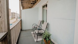 Ein Balkon mit zwei Stühlen, einem kleinen Tisch und einem Blumentopf.