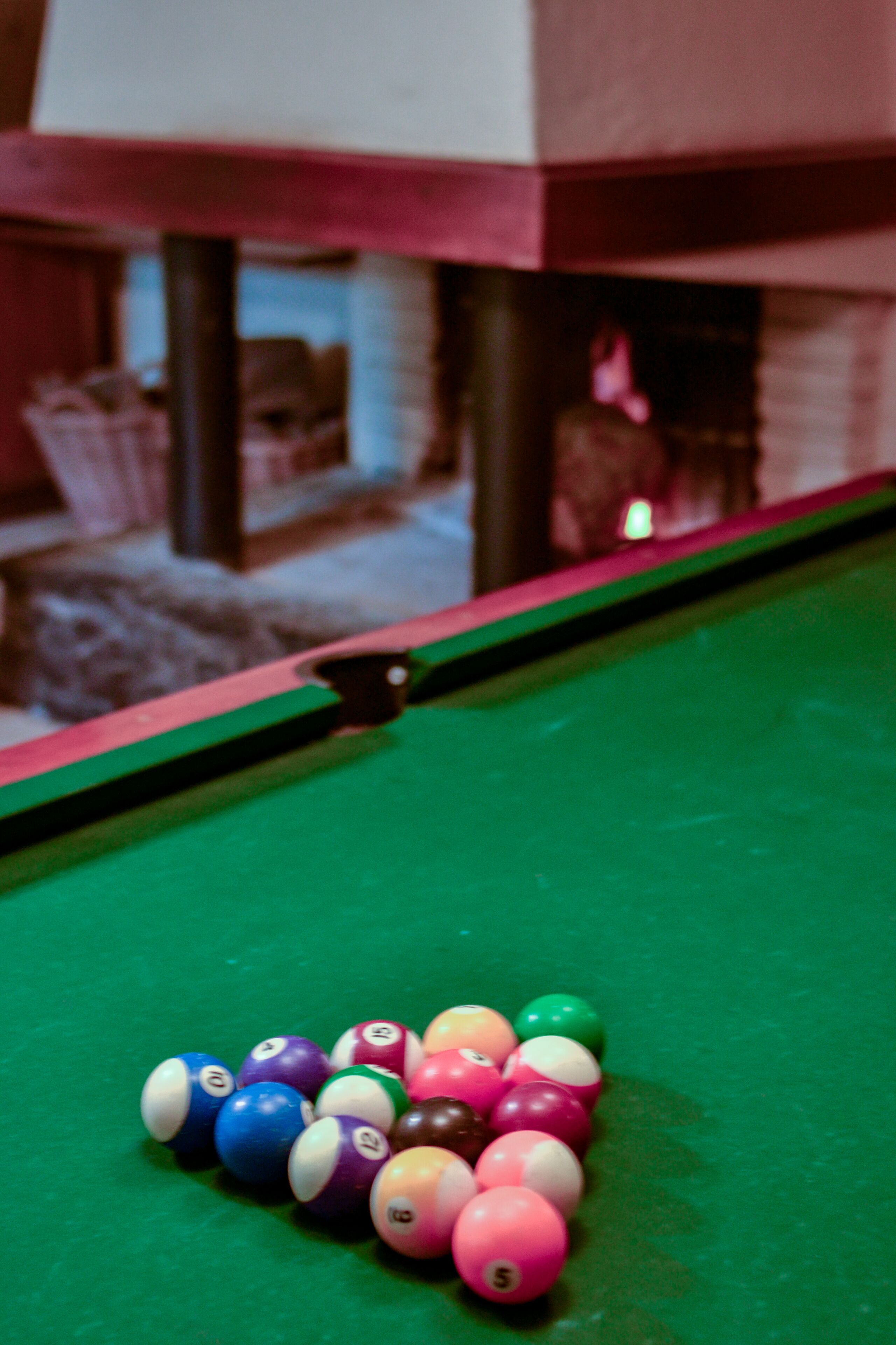 A pool table with colorful billiard balls and a green felt surface.