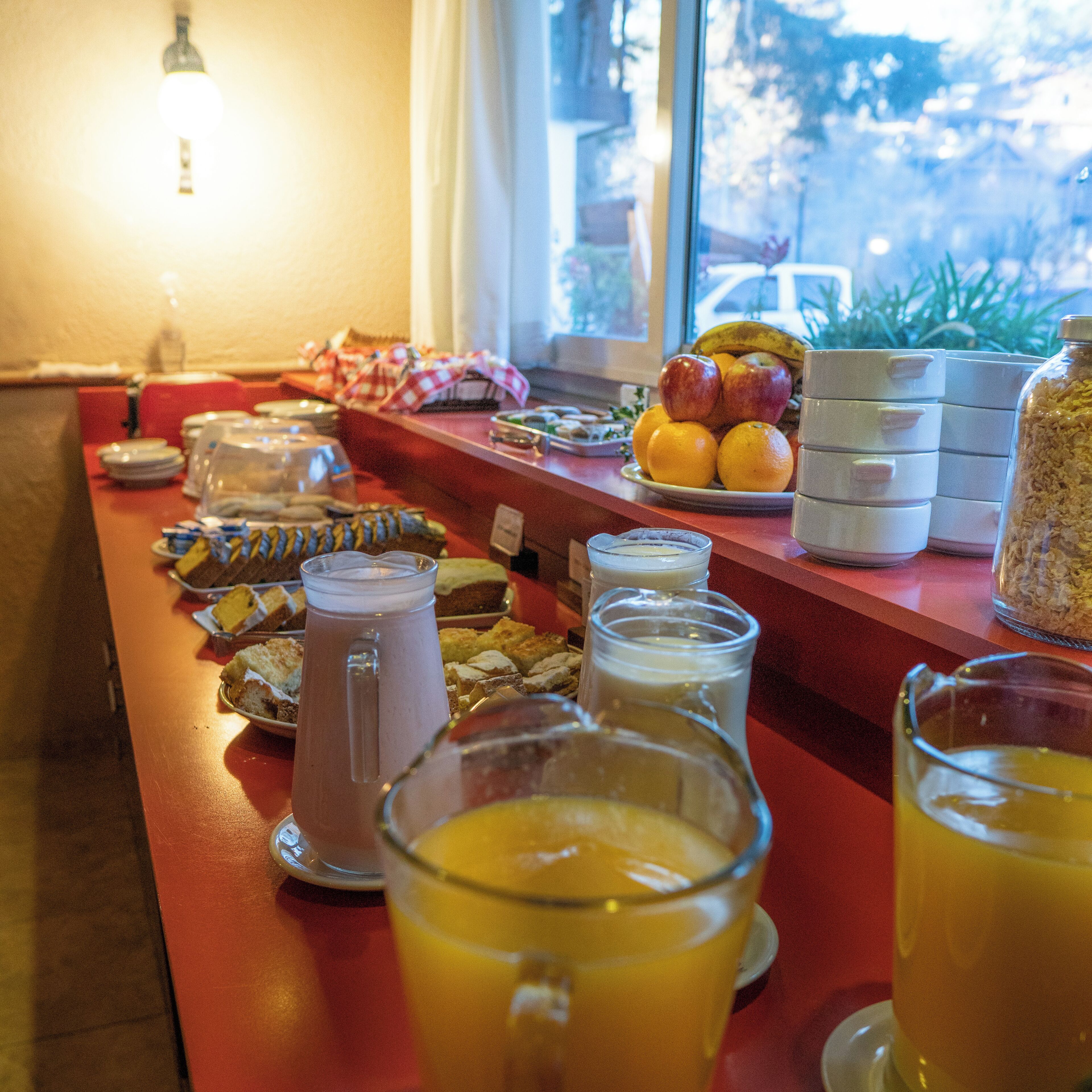 En morgenmadsbuffet med et udvalg af mad og drikkevarer.