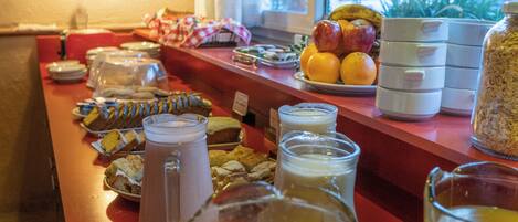 Um buffet de café da manhã com diversos alimentos e bebidas.
