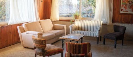 Un salón acogedor con sofá, sillones, una mesa de centro y una mesa de billar.