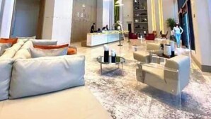 Un hall d’entrée spacieux avec un grand canapé, un comptoir d’accueil et une table basse.