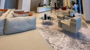 Un amplio vestíbulo con mostrador de recepción, zona de estar y un ventanal grande.
