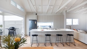 Una cucina moderna con un'isola grande, sgabelli da bar e frigorifero integrato.