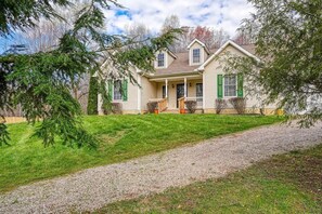 A two-story house with a front porch, a driveway, and a well-maintained lawn. - Ranch retreat in the heart of Hocking Hills (South Bloomingville)