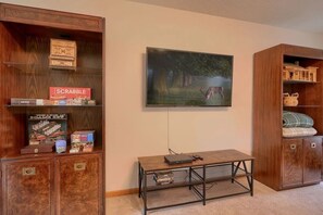 A room with a wooden cabinet, a television mounted on the wall, and a small table with a laptop. - Ranch retreat in the heart of Hocking Hills (South Bloomingville)