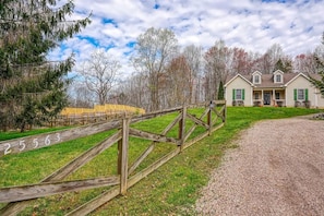 Une maison avec une allée en gravier et une clôture en bois portant des numéros.