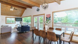 A spacious living area with a dining table, chairs, a sofa, and a television. - Muskoka Riverside Retreat on the Indian River in the heart of Port Carling (Port Carling)