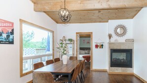 A dining area with a wooden table and chairs, a chandelier, and a fireplace. - Muskoka Riverside Retreat on the Indian River in the heart of Port Carling (Port Carling)