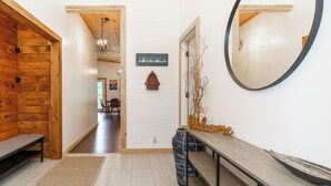 A hallway with a wooden bench, a welcome sign, a mirror, and a sign reading "MUSKOKA". - Muskoka Riverside Retreat on the Indian River in the heart of Port Carling (Port Carling)