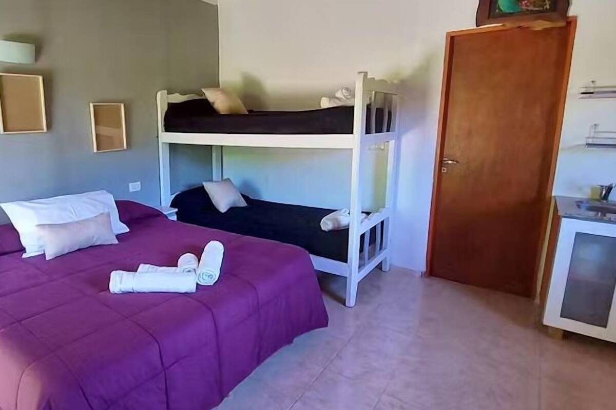 Een kamer met een stapelbed, een bureau en een kledingkast.