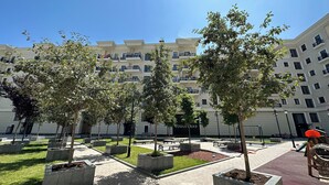 A courtyard with trees, benches, and a building labeled "Boulevard" in the background. - Tashkent City Boulevard (Tashkent)