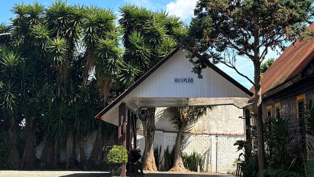 A building with a sign reading "RECEPCAO" under a clear blue sky. - Hotel São Luis  (Pinhao)
