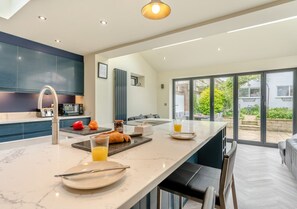 Enjoy a well-lit kitchen with a large island, microwave, and toaster, perfect for a breakfast setup.
