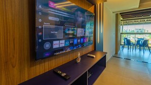 Un téléviseur à écran plat fixé au mur, qui est en bois, et qui affiche différentes plateformes de diffusion en continu.