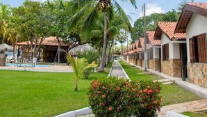 Zona residencial con casas, una palmera y un césped bien cuidado.