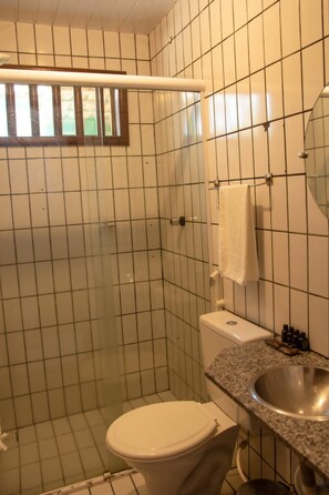 A bathroom with a toilet, sink, and a towel hanging on the wall.